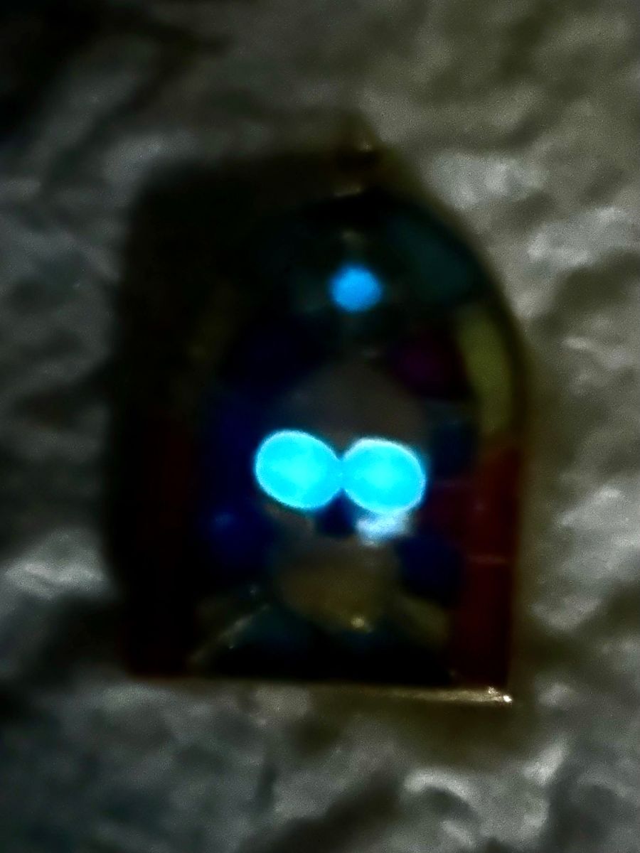 The same ornament with the lights out: the skull's two eyes glow bright blue